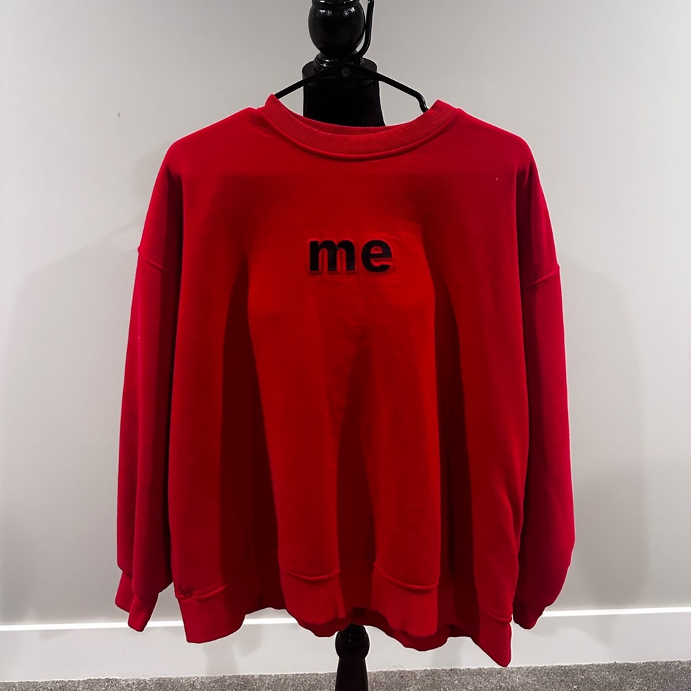 Red crewneck that says me at the front and one at the back.